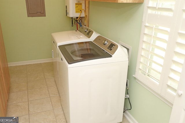 laundry area with water heater, washer and clothes dryer, and light tile patterned floors