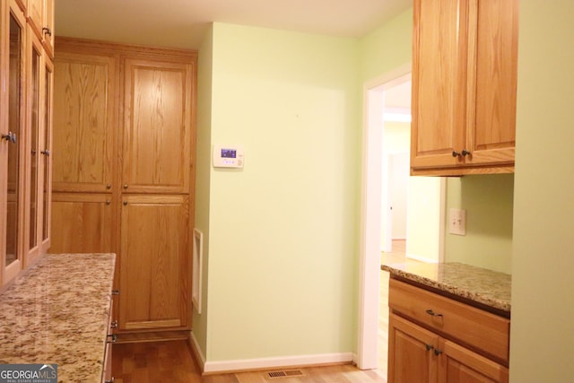 kitchen featuring light hardwood / wood-style flooring and light stone counters