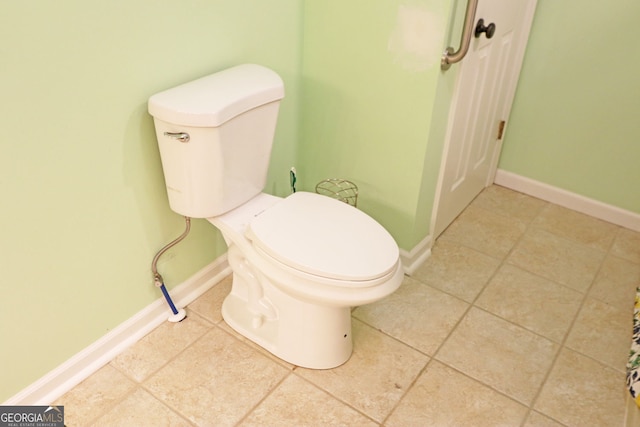 bathroom with toilet and tile patterned floors