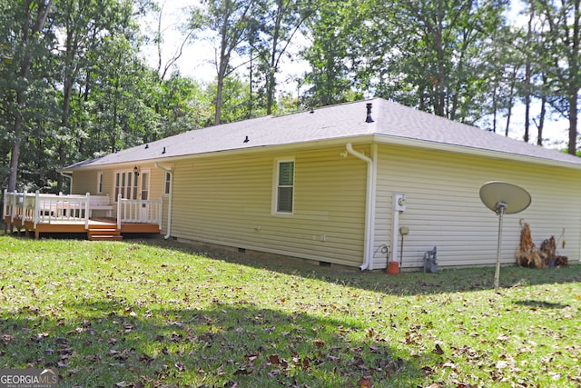 rear view of property featuring a yard and a deck