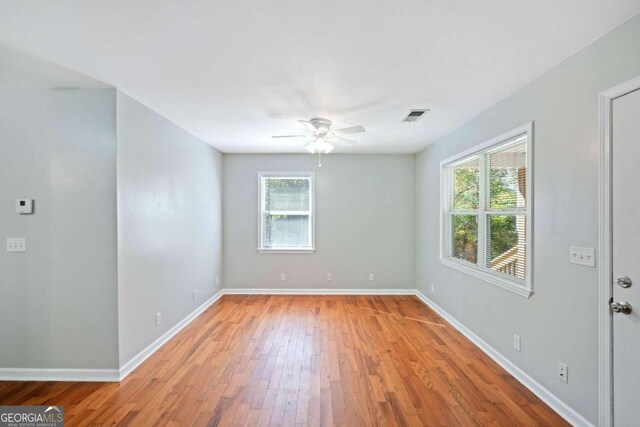 empty room featuring light wood-type flooring, plenty of natural light, and ceiling fan