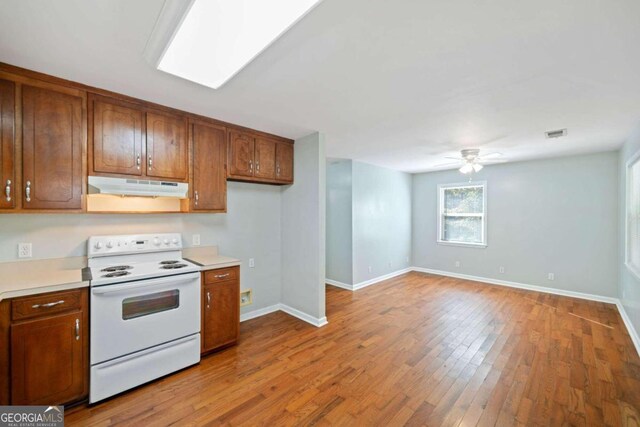 kitchen featuring white range with electric cooktop, light hardwood / wood-style floors, and ceiling fan