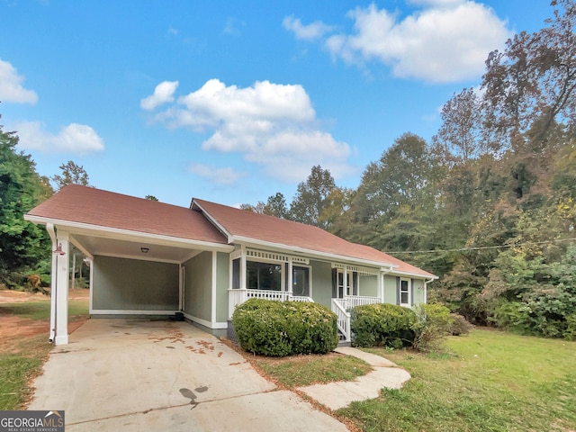 view of front facade with a porch, a front yard, and a carport