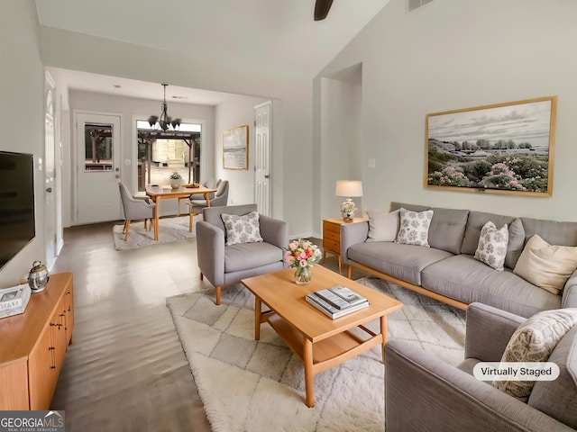 living room featuring lofted ceiling and an inviting chandelier