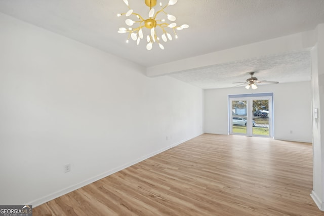 spare room with a textured ceiling, light hardwood / wood-style flooring, beam ceiling, and ceiling fan with notable chandelier