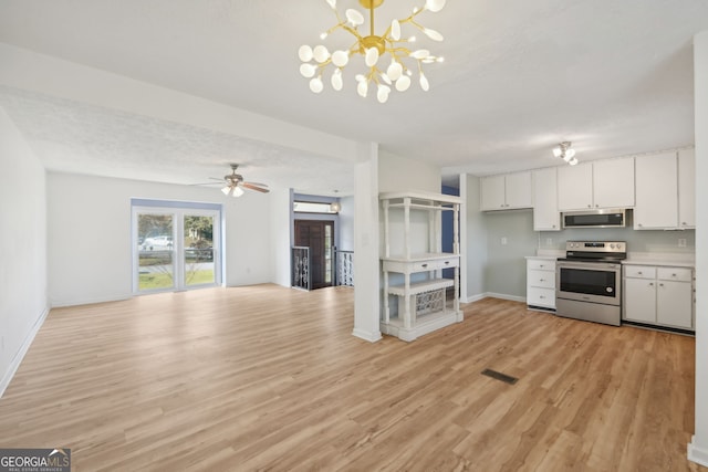 kitchen with open floor plan, stainless steel appliances, light countertops, light wood-type flooring, and white cabinetry