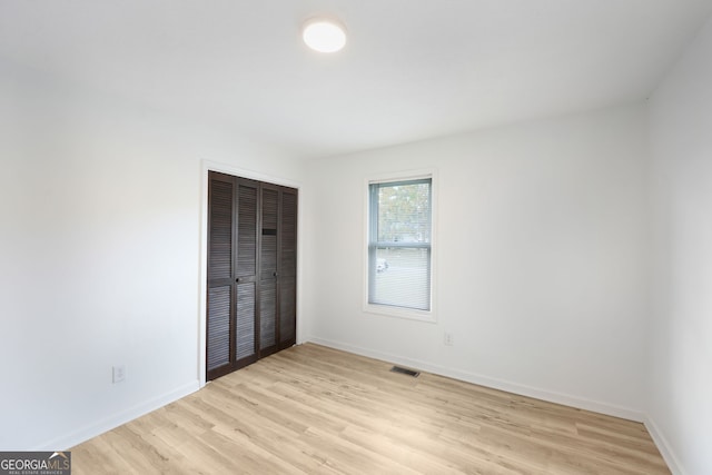 unfurnished bedroom featuring a closet and light hardwood / wood-style flooring