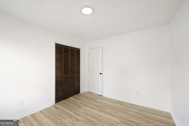 unfurnished bedroom featuring a closet and light hardwood / wood-style floors