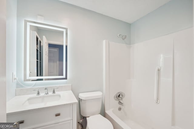 bathroom with washtub / shower combination, vanity, and toilet