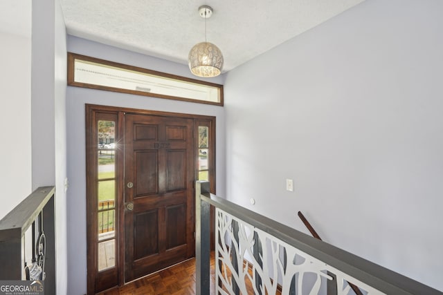 foyer entrance with a textured ceiling