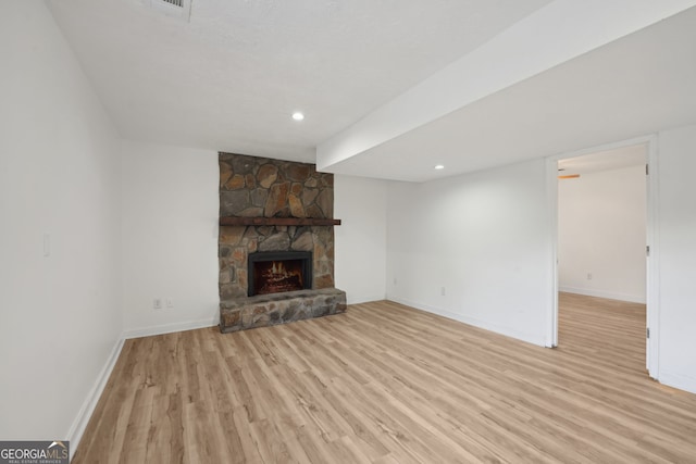 unfurnished living room with a fireplace and light wood-type flooring