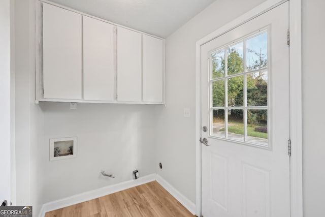 clothes washing area featuring cabinets, washer hookup, light wood-type flooring, and a wealth of natural light