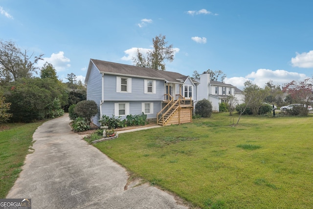 view of front of property with driveway, stairs, and a front lawn