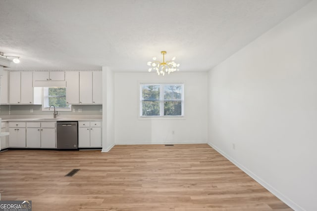 kitchen with stainless steel dishwasher, a chandelier, white cabinets, and light hardwood / wood-style flooring