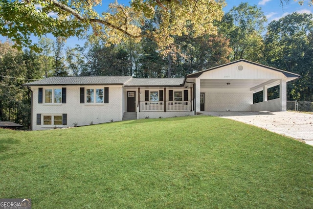 ranch-style house featuring a front lawn, covered porch, and a carport