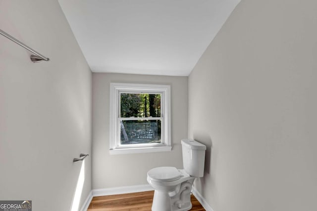 bathroom with lofted ceiling, hardwood / wood-style flooring, and toilet