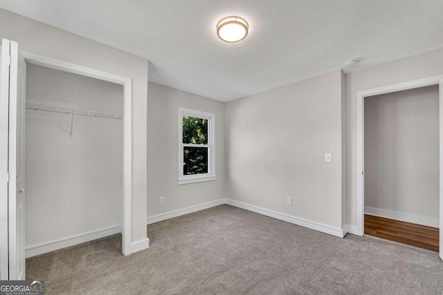 unfurnished bedroom with light carpet and a closet