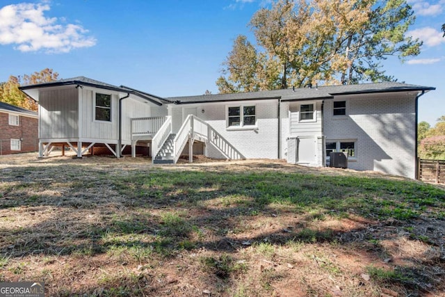 back of property with a yard and central AC unit