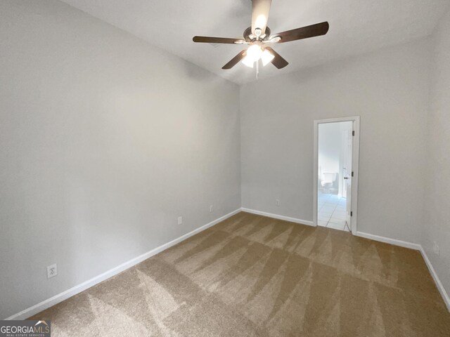 carpeted empty room with ceiling fan, lofted ceiling, and sink
