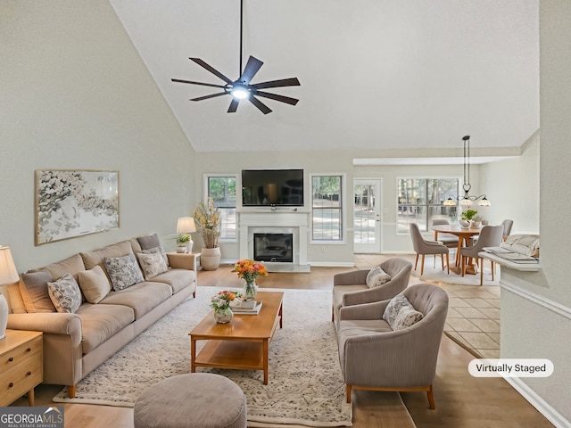 living room featuring ceiling fan, high vaulted ceiling, and wood-type flooring