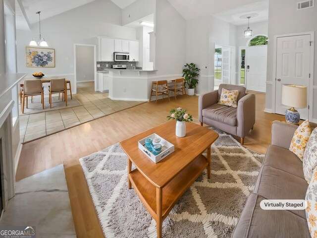 living room featuring ceiling fan, high vaulted ceiling, and wood-type flooring