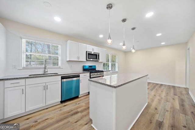 kitchen with white cabinets, stainless steel appliances, sink, and a wealth of natural light