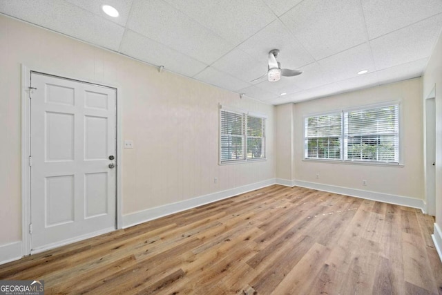 unfurnished room with ceiling fan, light hardwood / wood-style flooring, and a paneled ceiling