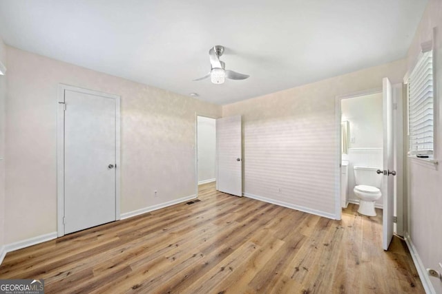 unfurnished bedroom featuring connected bathroom, light hardwood / wood-style flooring, and ceiling fan