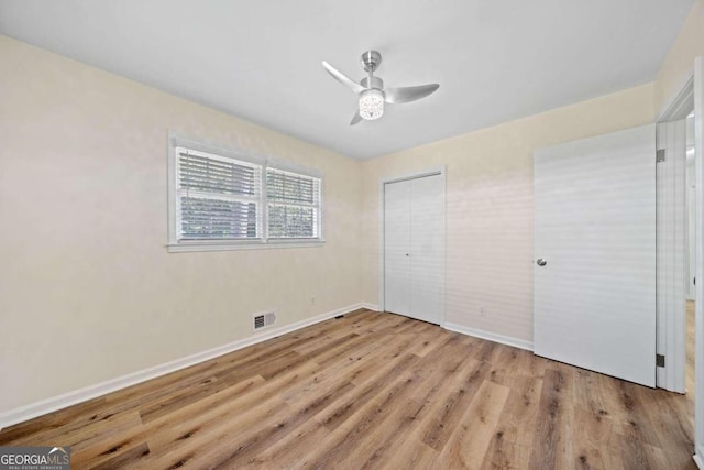 unfurnished bedroom featuring light hardwood / wood-style flooring, a closet, and ceiling fan