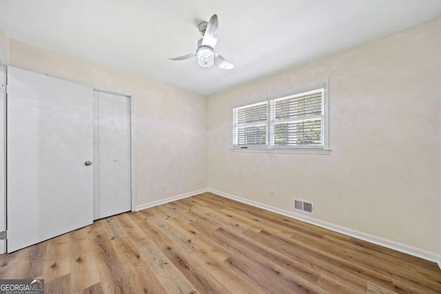 unfurnished bedroom with a closet, light wood-type flooring, and ceiling fan