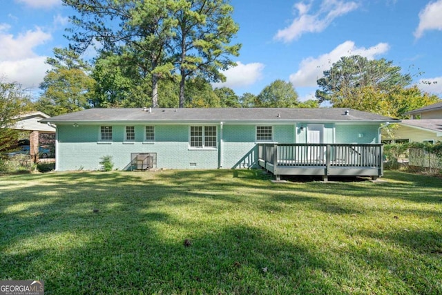 rear view of property with a deck and a yard