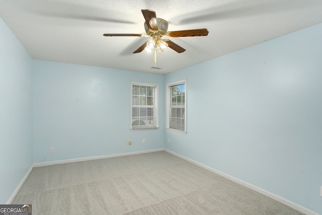 empty room with a textured ceiling, light carpet, and ceiling fan