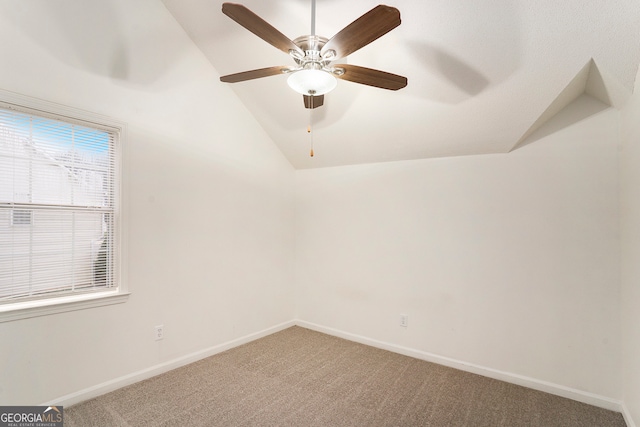 carpeted empty room with ceiling fan and vaulted ceiling