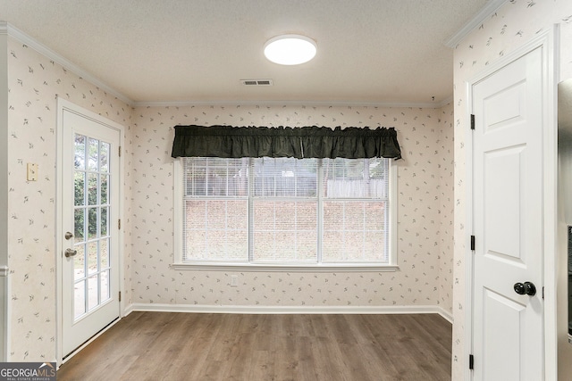 interior space with hardwood / wood-style floors, a textured ceiling, and crown molding