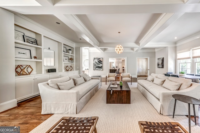 living room featuring hardwood / wood-style flooring, beamed ceiling, a chandelier, crown molding, and built in features