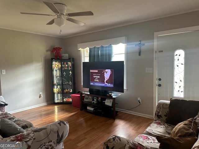 living room featuring crown molding, wood-type flooring, and ceiling fan