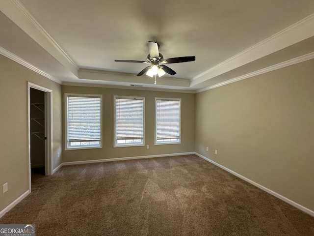 carpeted empty room featuring ornamental molding, a tray ceiling, and ceiling fan