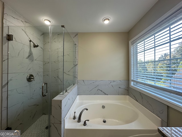 bathroom featuring independent shower and bath