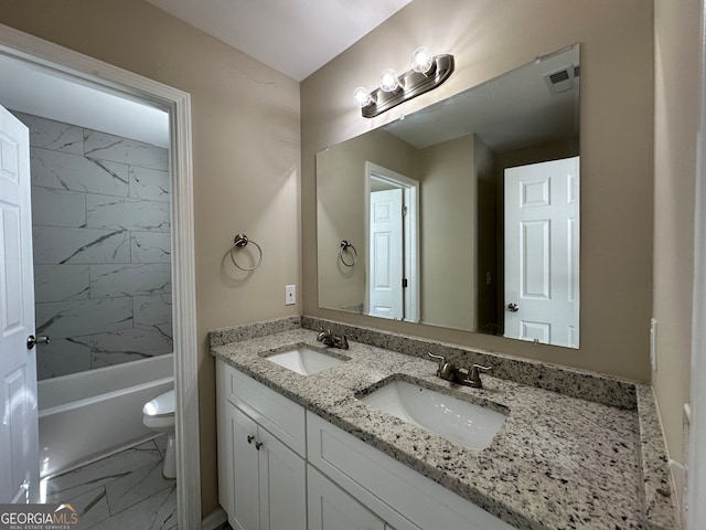 full bathroom featuring tiled shower / bath, vanity, and toilet