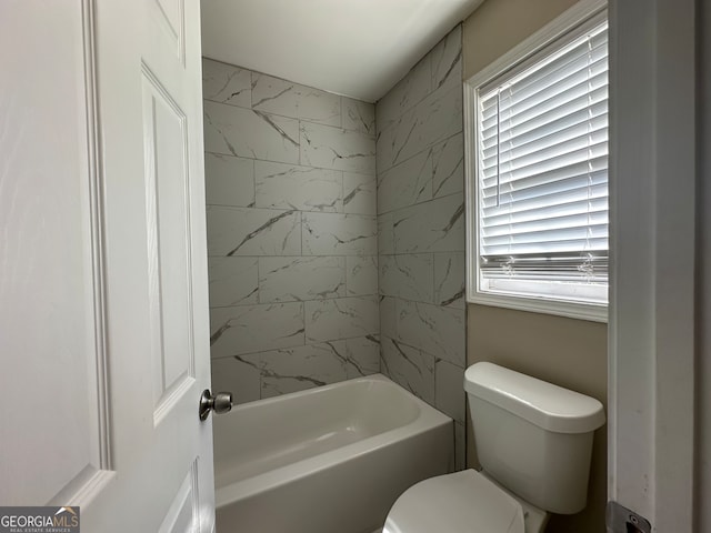 bathroom with toilet and tiled shower / bath