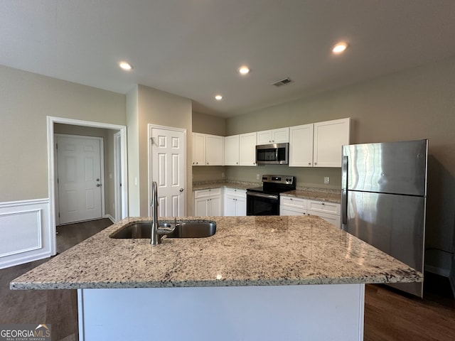 kitchen featuring stainless steel appliances, sink, a center island with sink, and white cabinets