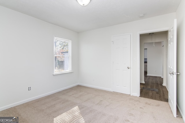 unfurnished bedroom featuring light carpet and a closet