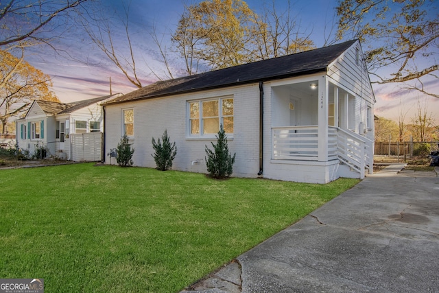 single story home featuring covered porch and a yard