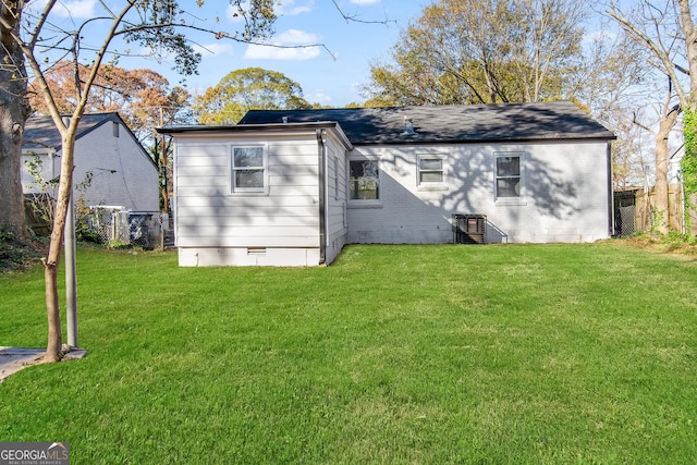 rear view of property featuring a yard