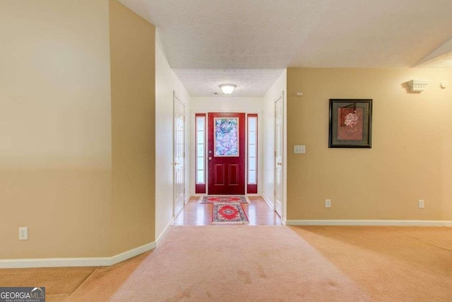 carpeted entryway featuring a textured ceiling