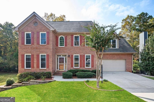 colonial-style house featuring a front yard and a garage