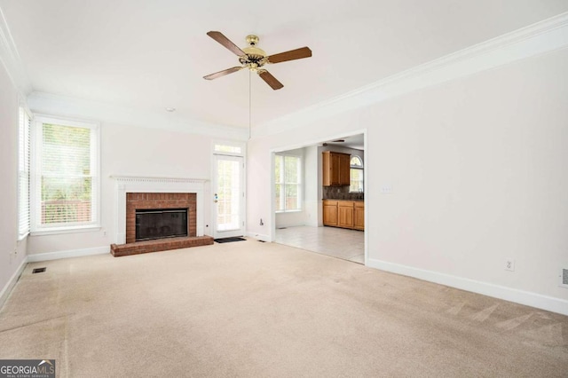 unfurnished living room with crown molding, light carpet, and plenty of natural light