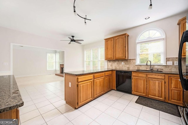 kitchen featuring black dishwasher, sink, kitchen peninsula, and a healthy amount of sunlight