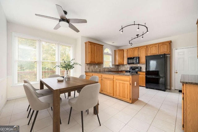 kitchen featuring tasteful backsplash, light tile patterned floors, ceiling fan, black appliances, and sink