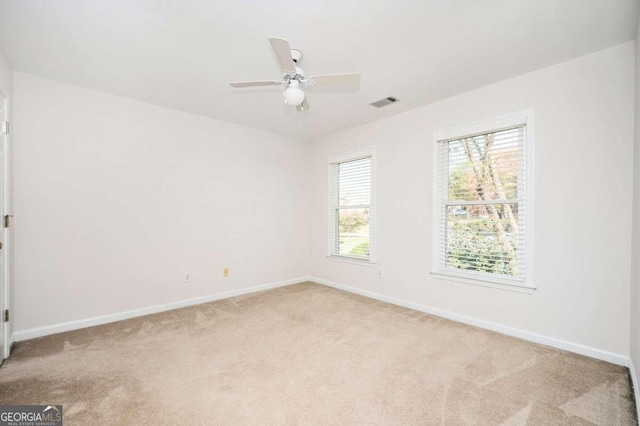 spare room featuring light carpet and ceiling fan